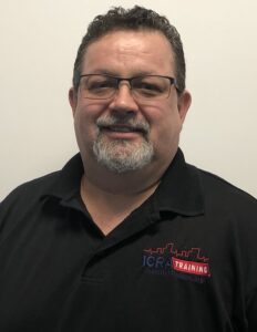 A man with glasses and beard wearing black shirt.